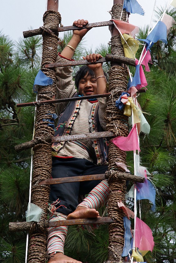 Dongba Village. Boy climbing up a ladder of knifes. Dongba Village. .