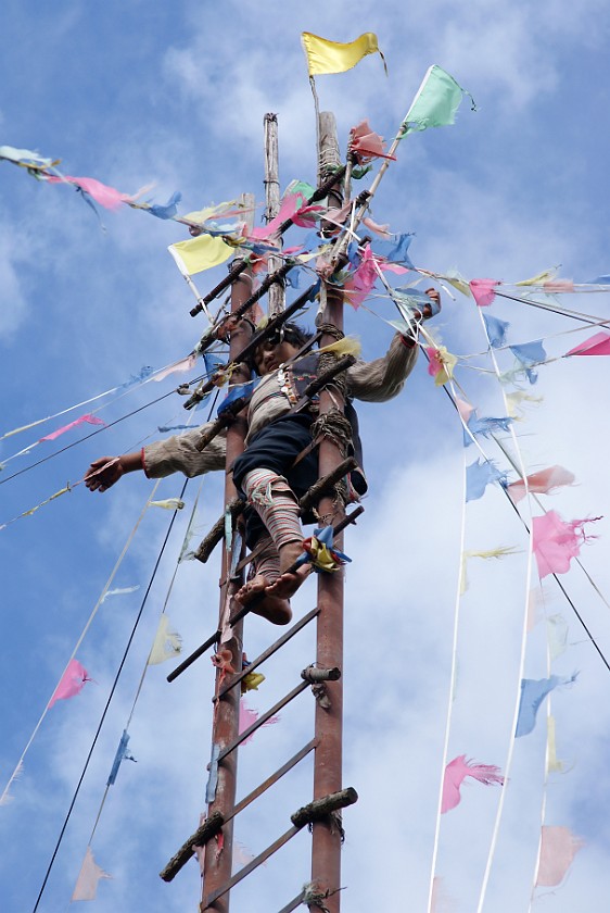 Dongba Village. Boy climbing up a ladder of knifes. Dongba Village. .